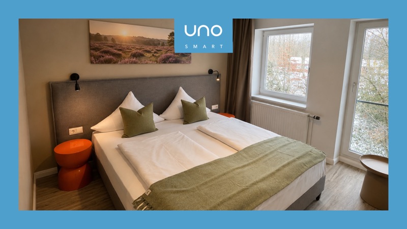 Modern renoviertes Doppelzimmer im UNO Smart Soltau-Wietzendorf mit Bild der Lüneburger Heide über dem Bett
