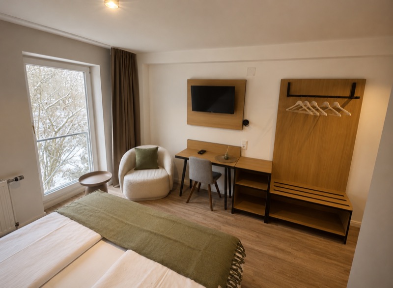 Sitzbereich, Garderobe und Arbeitsplatz im Doppelzimmer